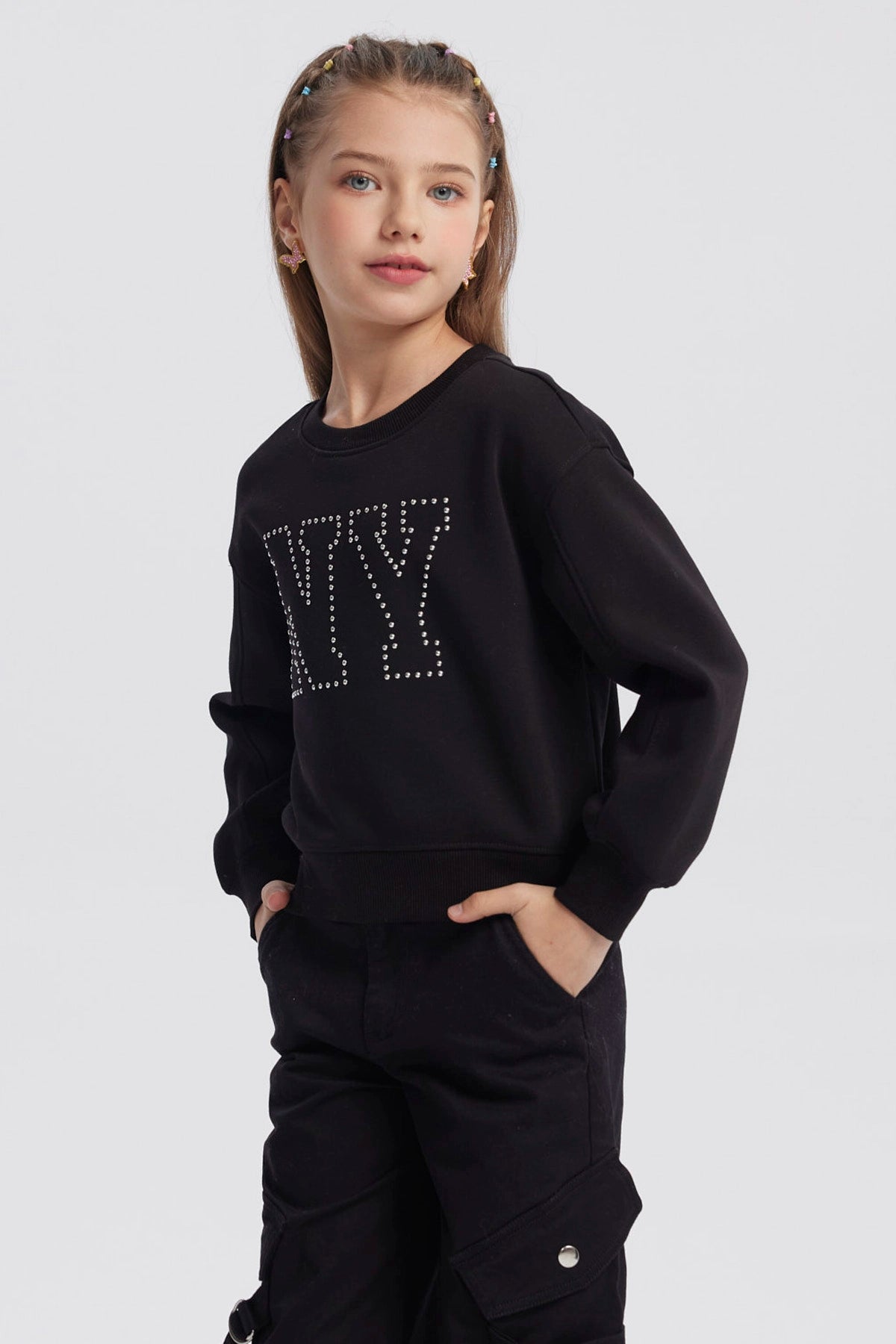 Polerón negro para niña con diseño de strass formando las letras NY en el pecho estilo casual y moderno