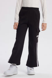 Pantalón buzo negro niña con bolsillo lateral y texto New York Dreams en la pierna estilo casual relajado