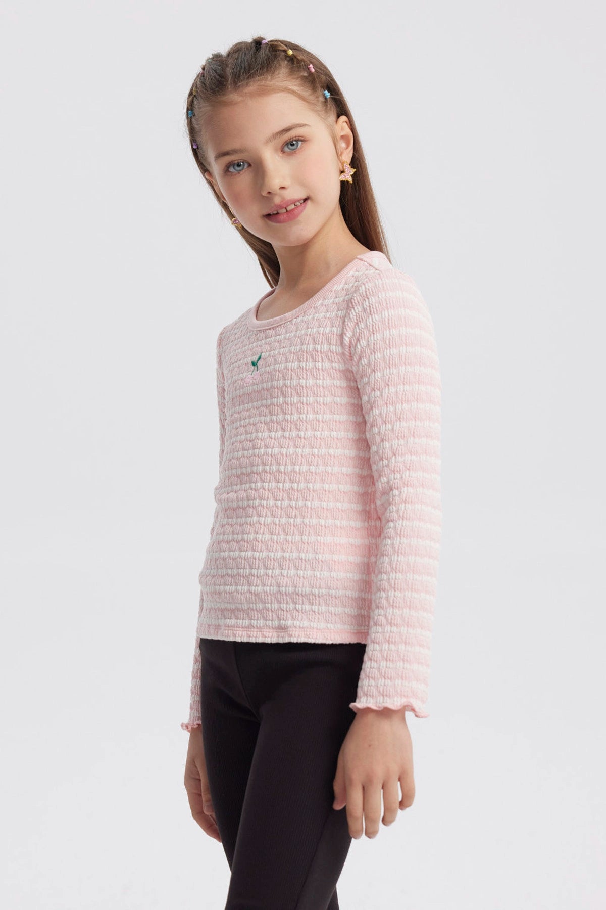 Polera rosada de rayas para niña con diseño liso y detalle pequeño bordado en el pecho