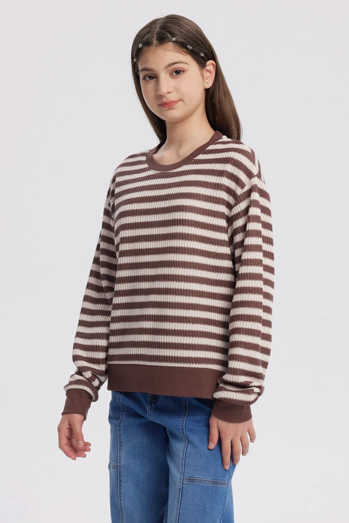 Polerón niña cuello redondo café con rayas blancas horizontales diseño casual y relajado sin estampa visible