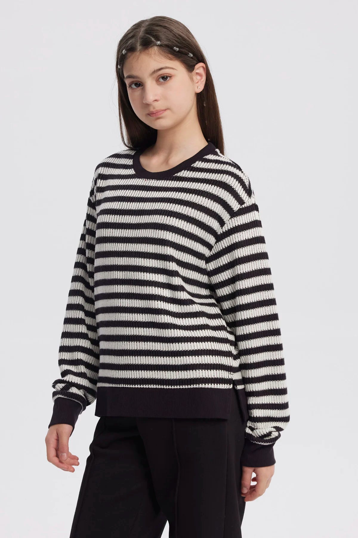 Polerón niña cuello redondo negro con rayas horizontales blancas diseño casual y relajado sin estampa visible