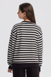 Polerón niña cuello redondo negro con rayas horizontales blancas diseño casual y relajado sin estampa visible