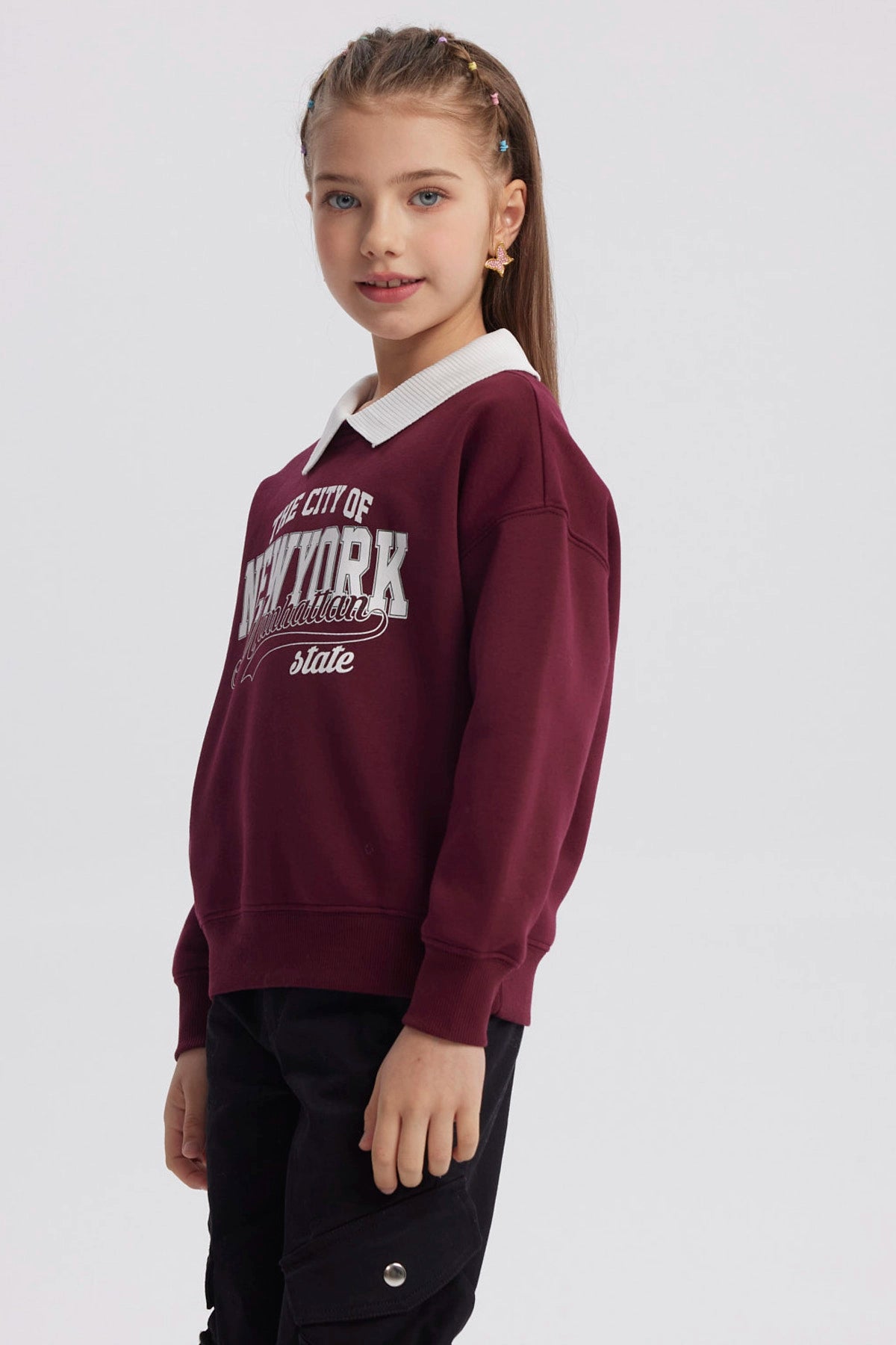Polerón burdeo niña con cuello camisero blanco y estampado frontal grande The City of New York Manhattan state en tipografía deportiva