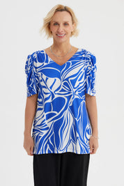 Polera azulino para mujer con estampado abstracto blanco estilo hojas en toda la prenda y mangas fruncidas