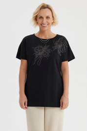 Polera mujer cuello bote negra con estampado de líneas brillantes en el pecho estilo floral gráfico elegante