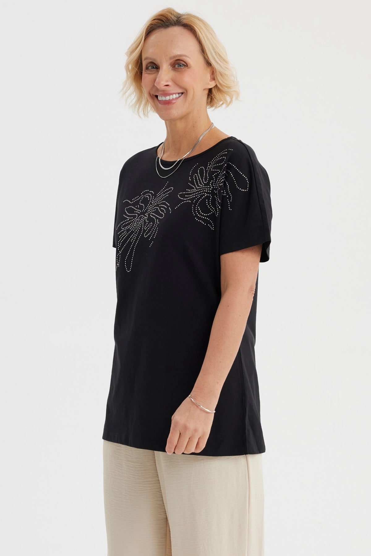 Polera mujer cuello bote negra con estampado de líneas brillantes en el pecho estilo floral gráfico elegante