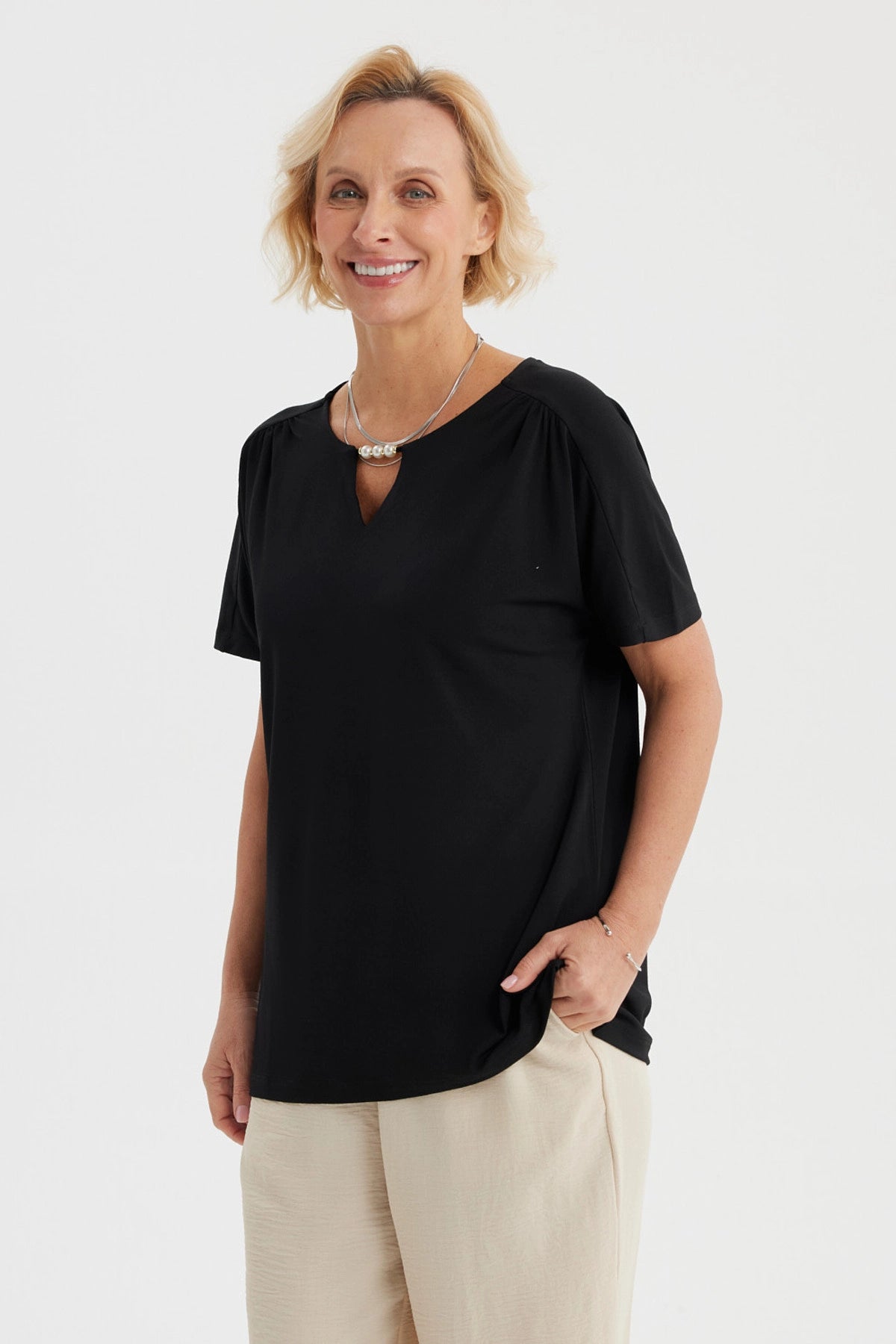 Polera negra de mujer con detalle de perlas en el escote liso y elegante perfecta para ocasiones casuales