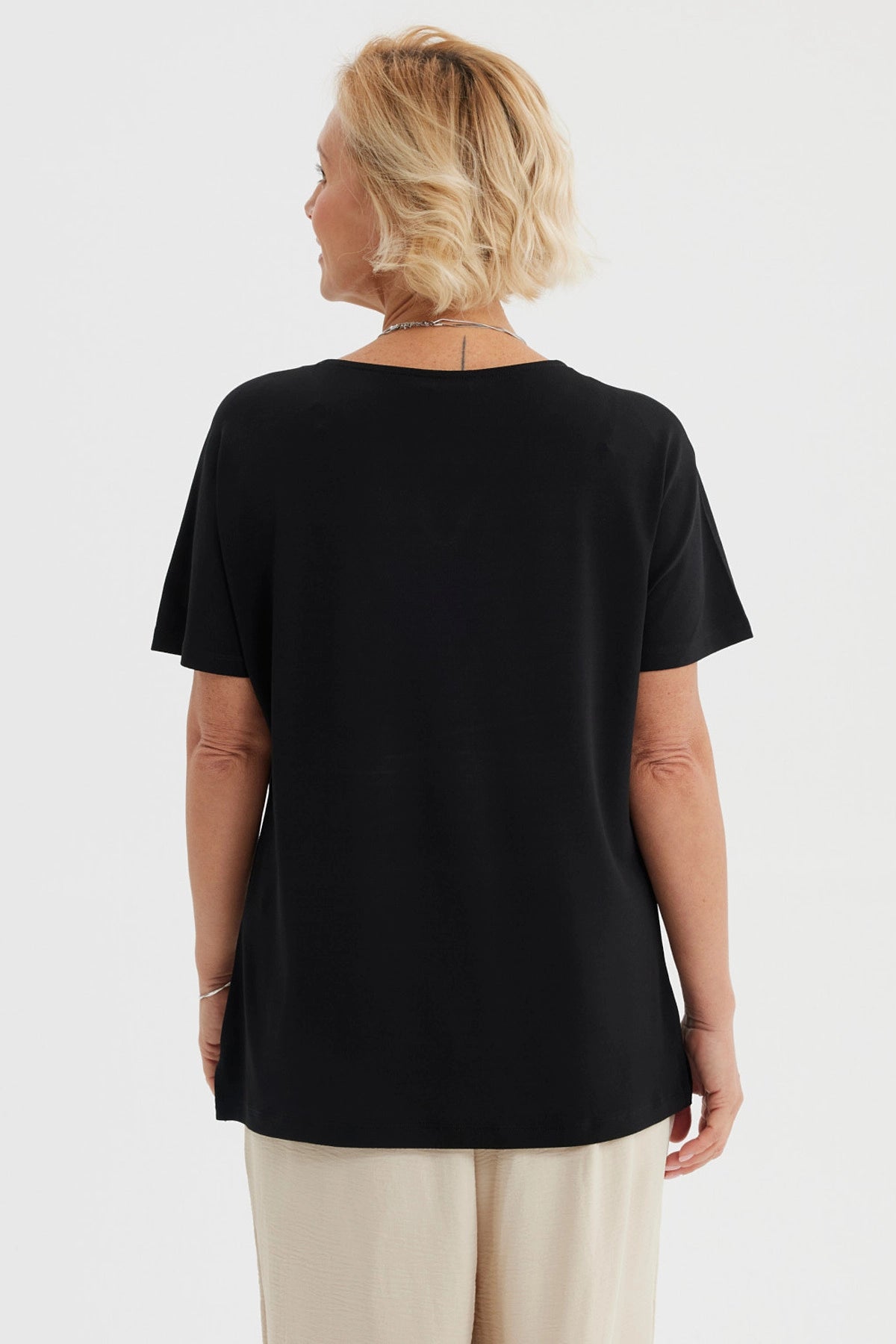 Polera negra de mujer con detalle de perlas en el escote liso y elegante perfecta para ocasiones casuales
