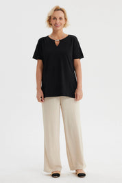 Polera negra de mujer con detalle de perlas en el escote liso y elegante perfecta para ocasiones casuales