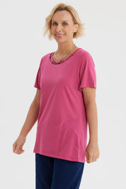 Polera magenta para mujer con detalle de cuello decorativo en el centro diseño liso estilo casual relajado
