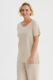 Polera mujer beige claro con detalle de cintas entrelazadas en el cuello estilo casual y corte recto lisa