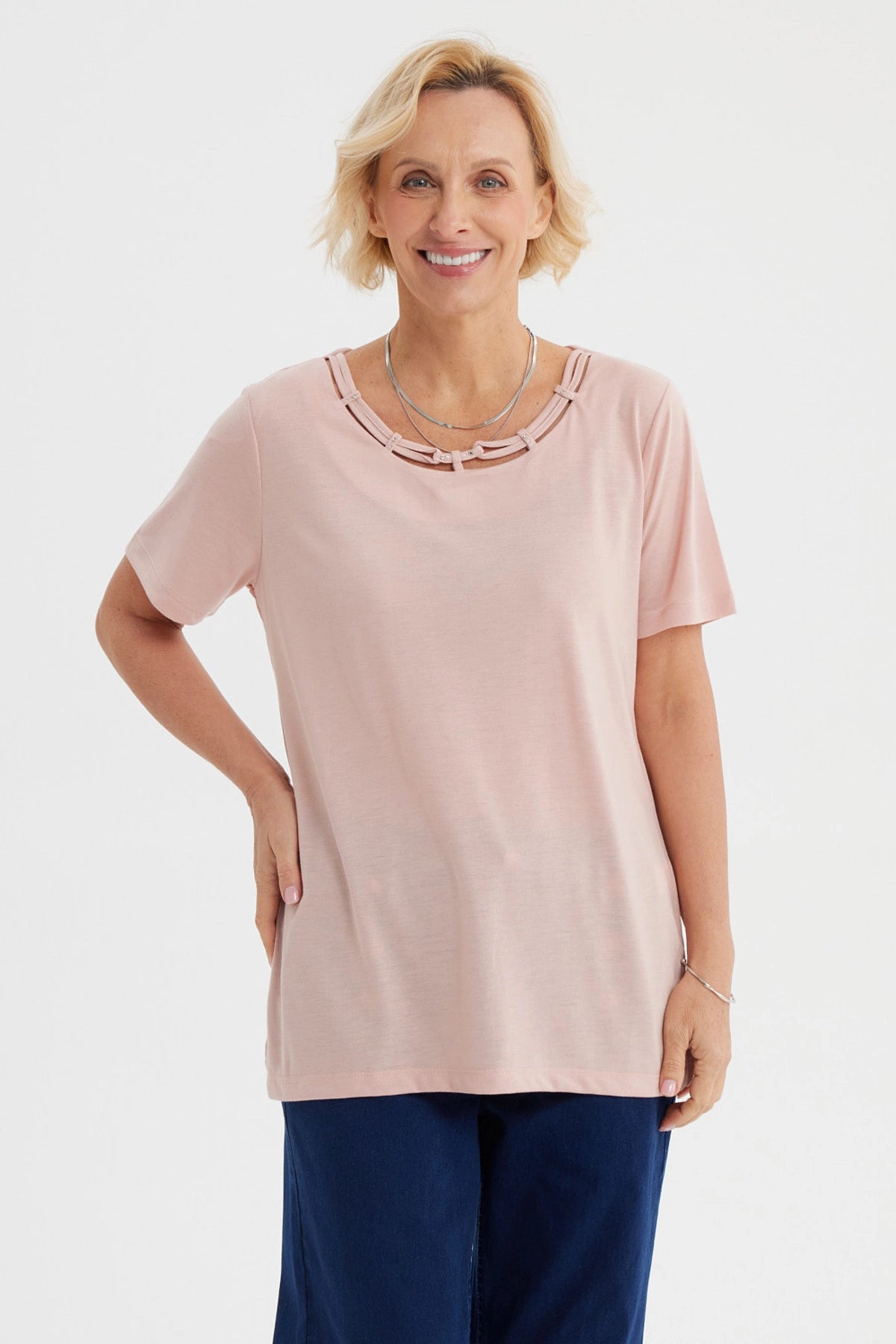 Polera de mujer rosada con detalle decorativo en el cuello lisa de manga corta y corte recto