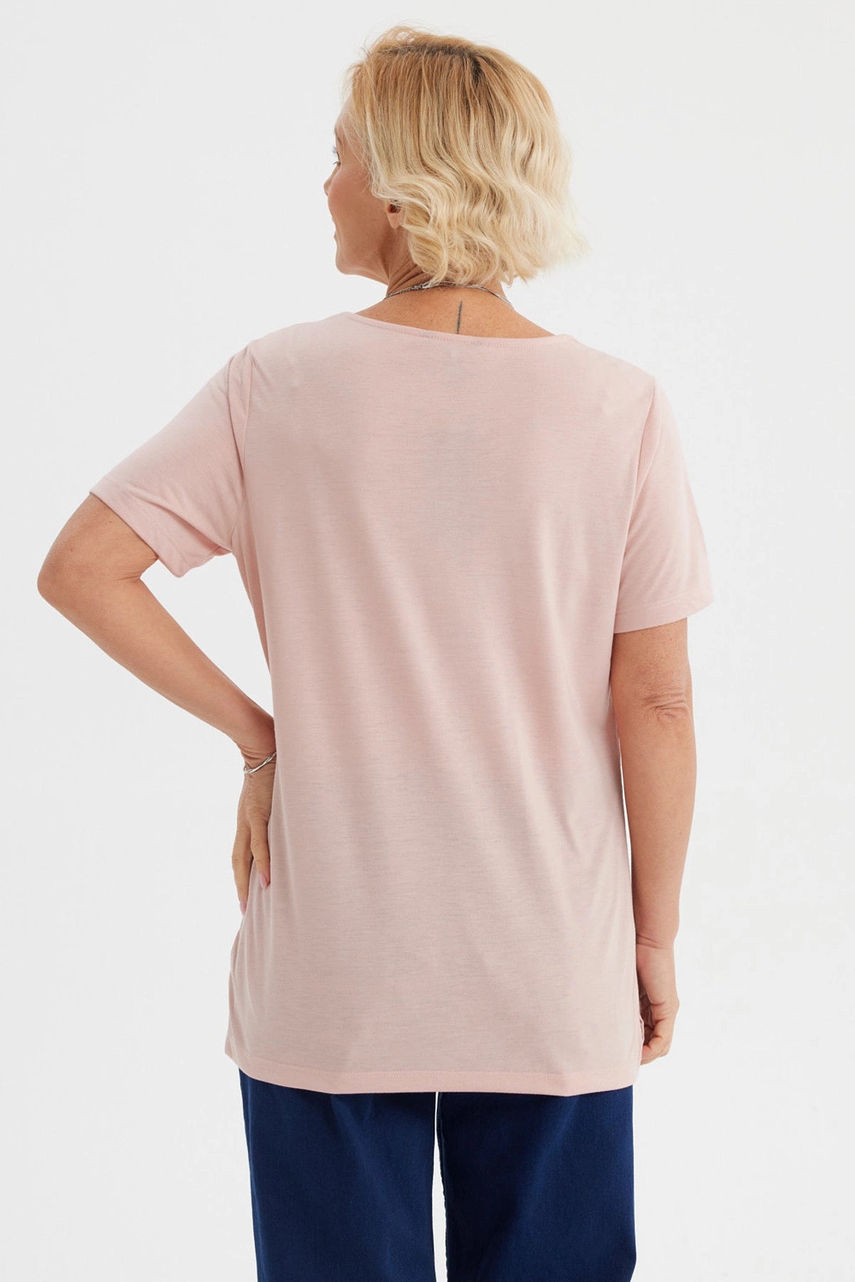 Polera de mujer rosada con detalle decorativo en el cuello lisa de manga corta y corte recto