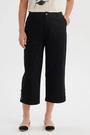 Pantalón pescador negro mujer con botones laterales en los bajos y detalle de pretina lisa elegante