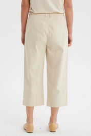 Pantalón pescador beige claro mujer con detalle de pretina lisa y botones decorativos en los bajos