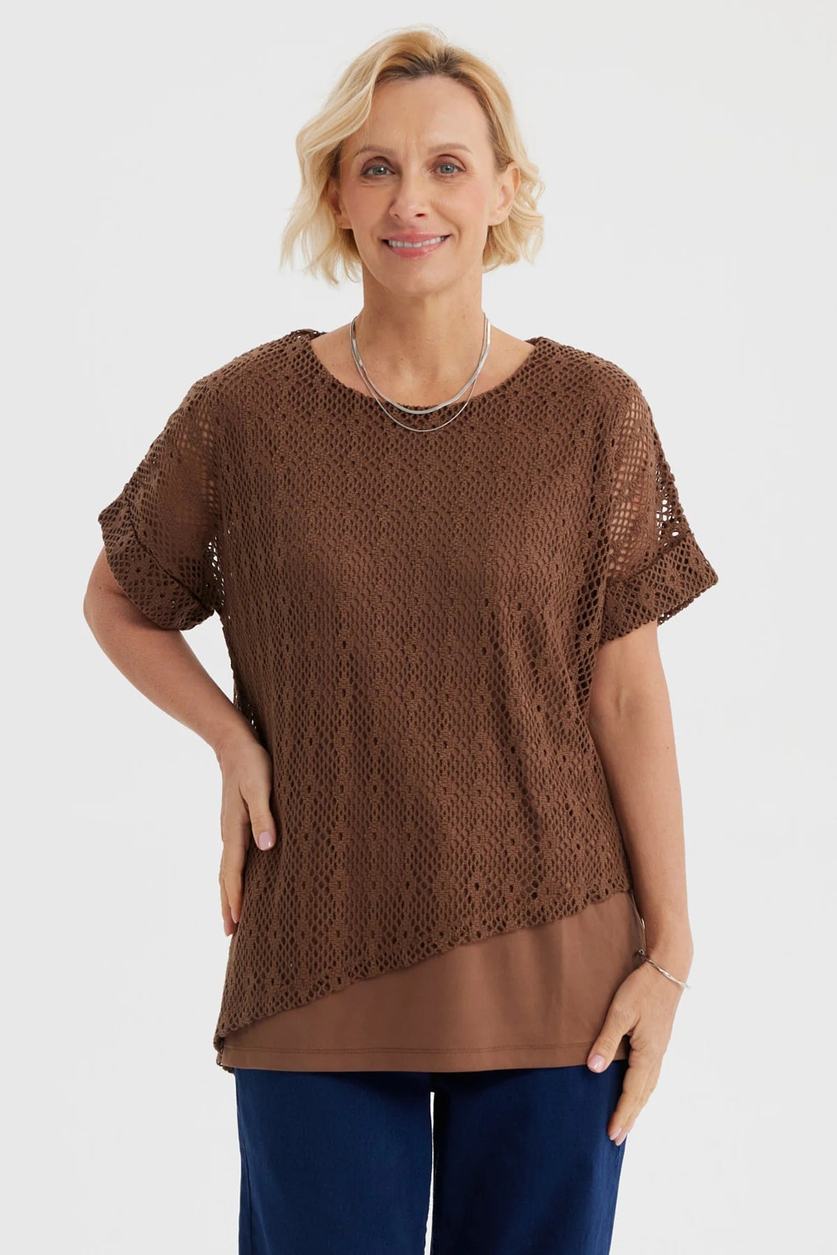 Polera mujer café calada con diseño tejido superpuesta sobre capa lisa perfecta para días de primavera sin estampa visible