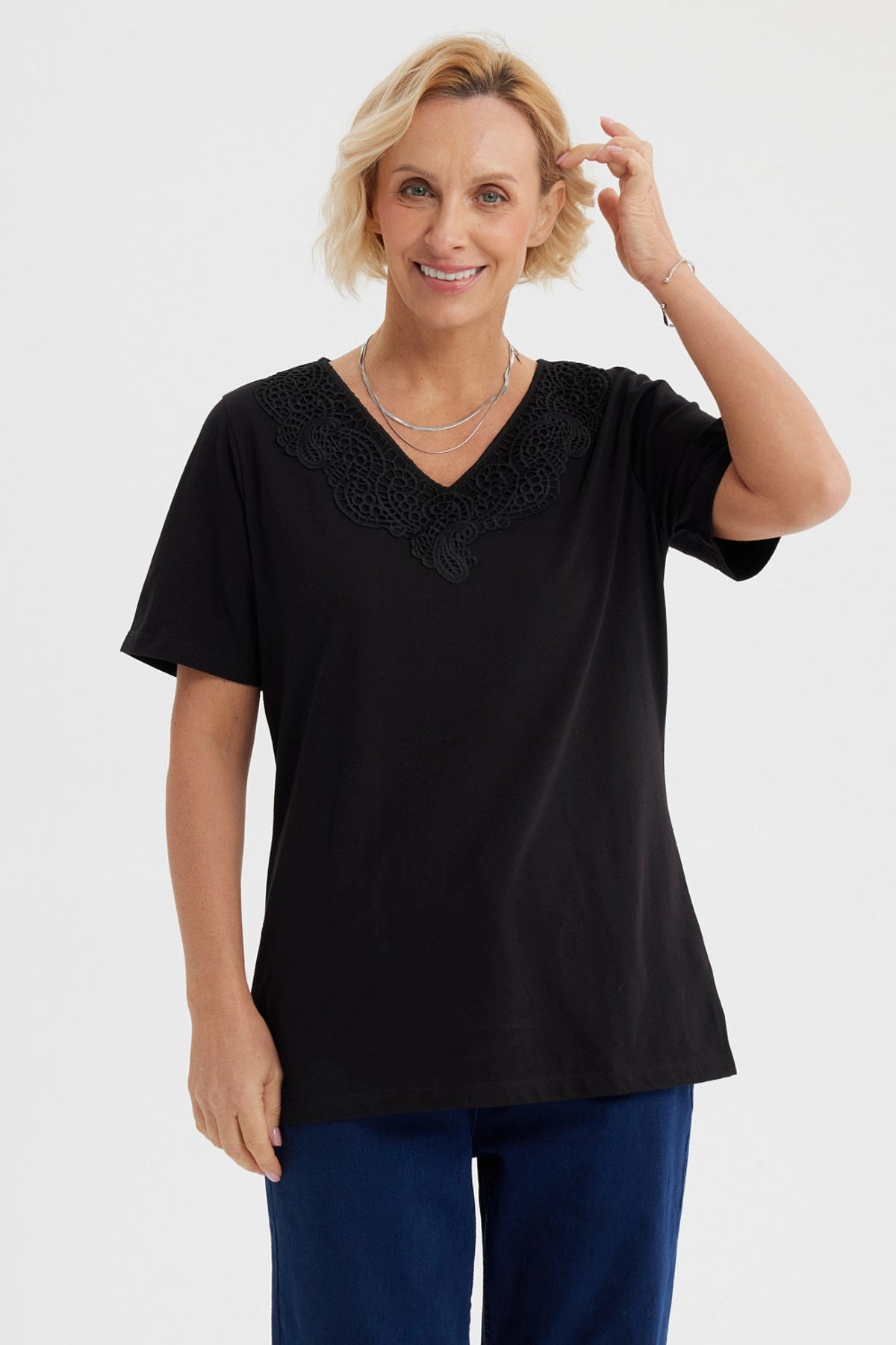 Polera negra de mujer con detalle de macramé en el escote en forma de V diseño elegante y sin estampa visible