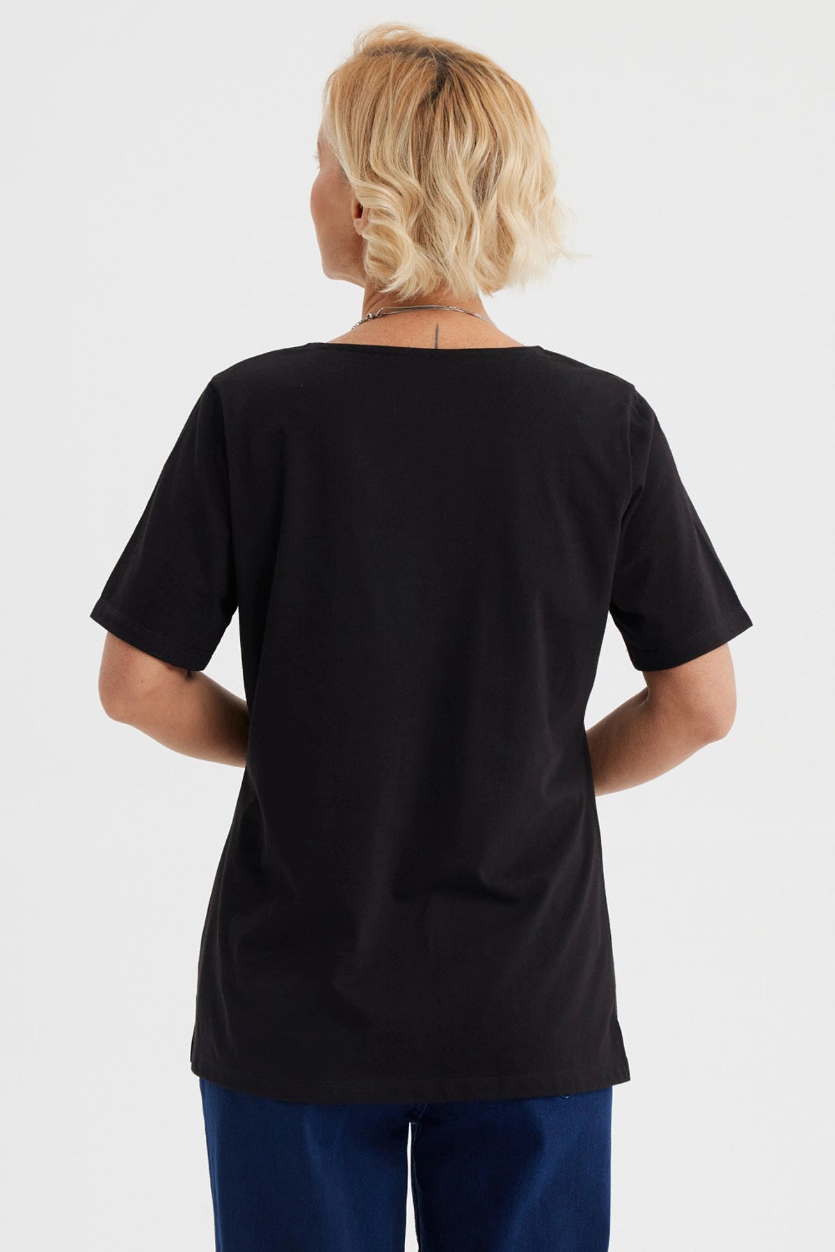 Polera negra de mujer con detalle de macramé en el escote en forma de V diseño elegante y sin estampa visible