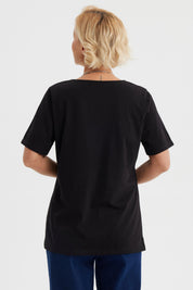 Polera negra de mujer con detalle de macramé en el escote en forma de V diseño elegante y sin estampa visible