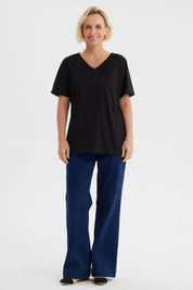 Polera negra de mujer con detalle de macramé en el escote en forma de V diseño elegante y sin estampa visible