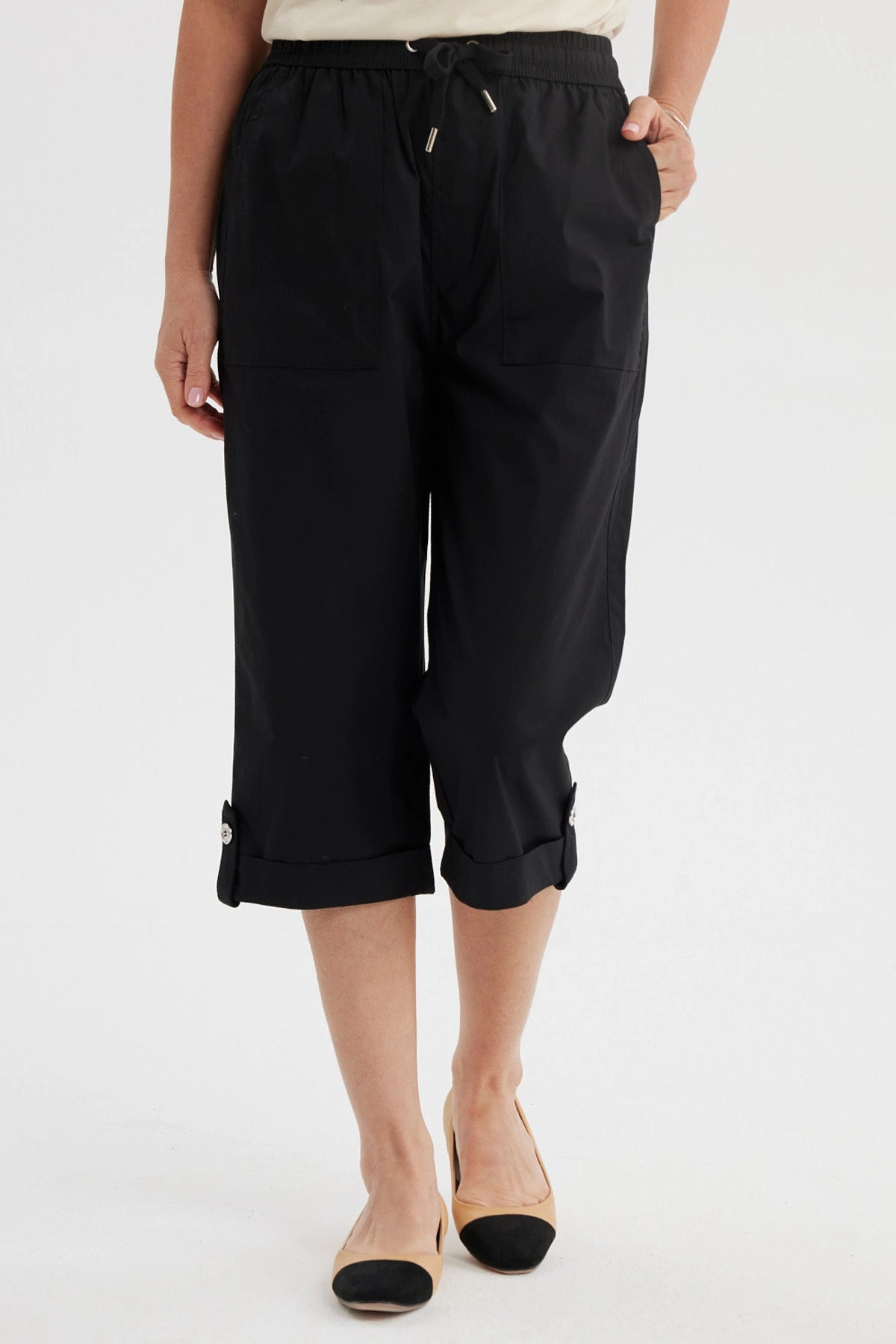 Pantalón pescador negro con cortes y aperturas detalles en la parte inferior liso con cintura elástica y bolsillos delanteros