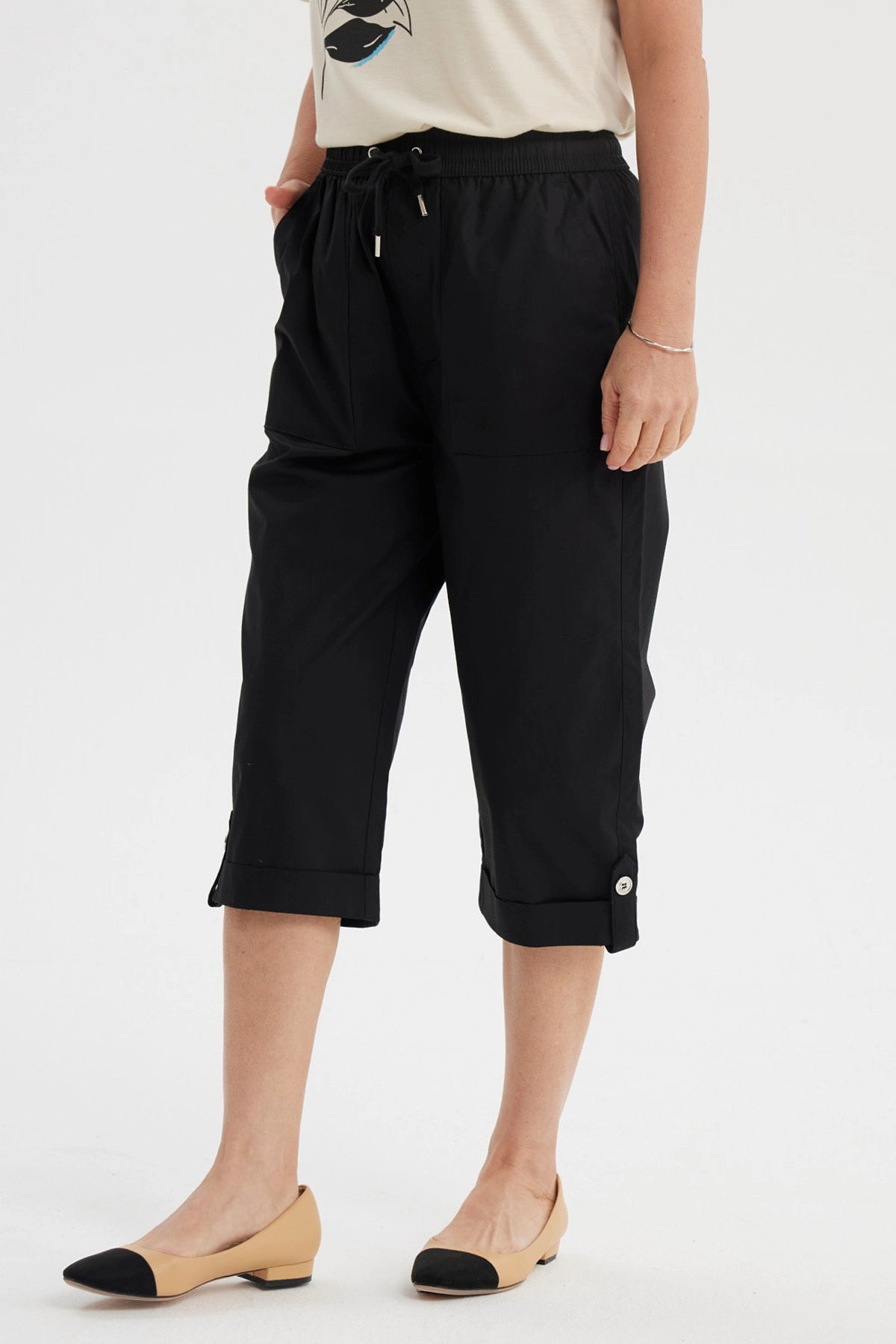 Pantalón pescador negro con cortes y aperturas detalles en la parte inferior liso con cintura elástica y bolsillos delanteros