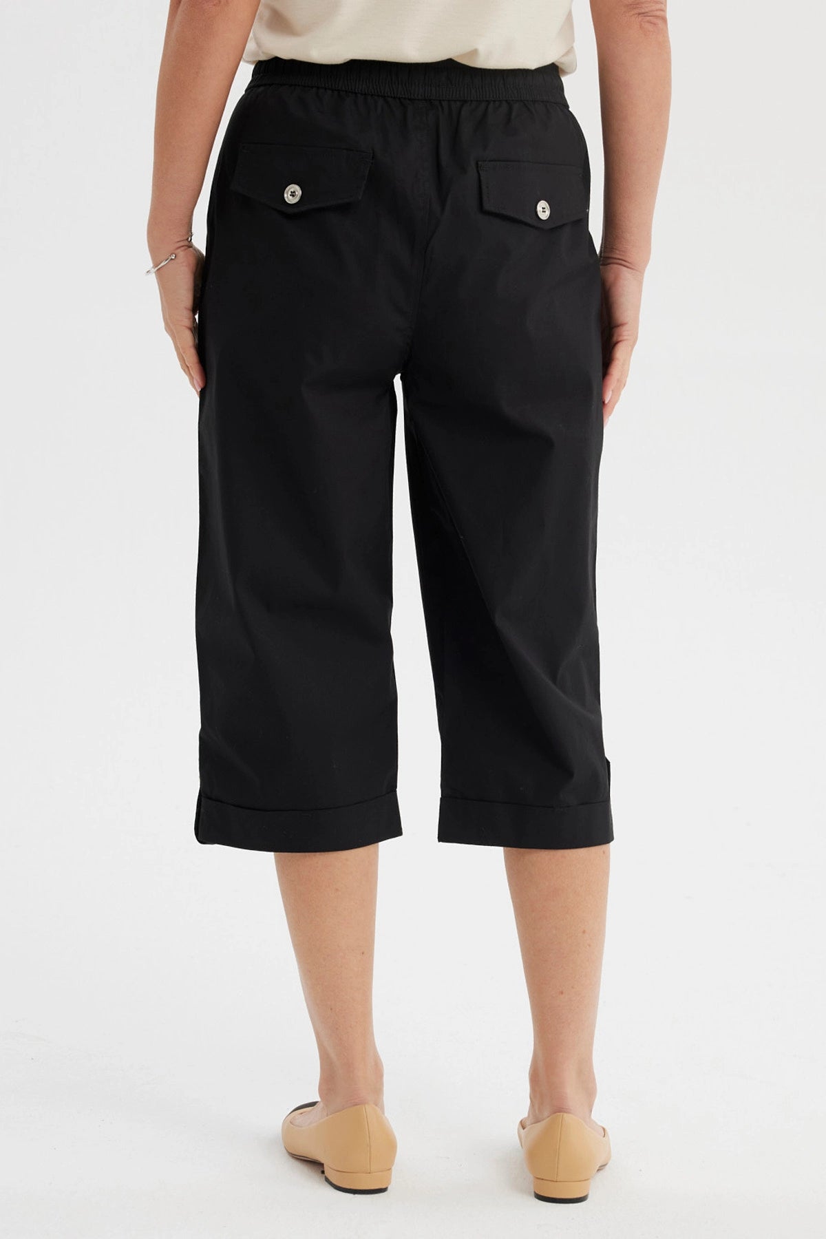 Pantalón pescador negro con cortes y aperturas detalles en la parte inferior liso con cintura elástica y bolsillos delanteros