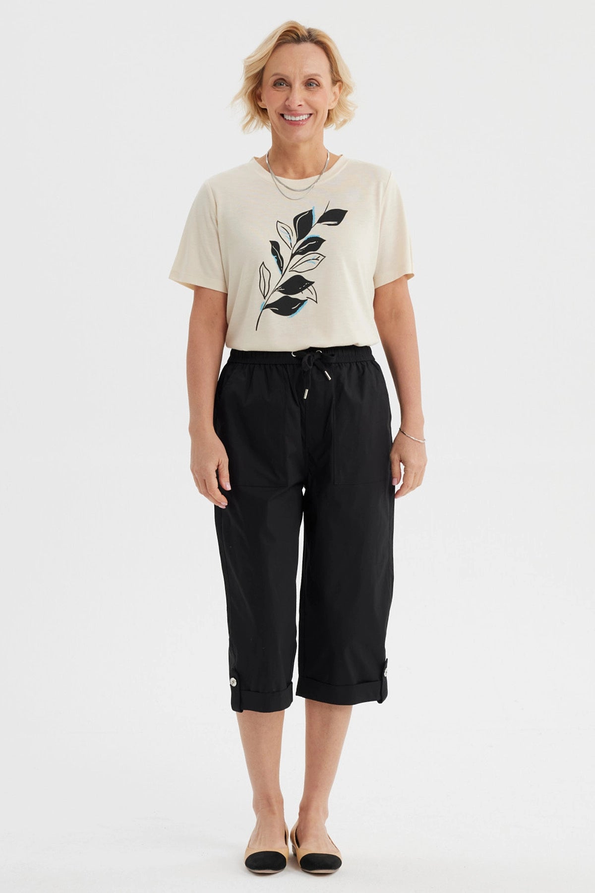 Pantalón pescador negro con cortes y aperturas detalles en la parte inferior liso con cintura elástica y bolsillos delanteros