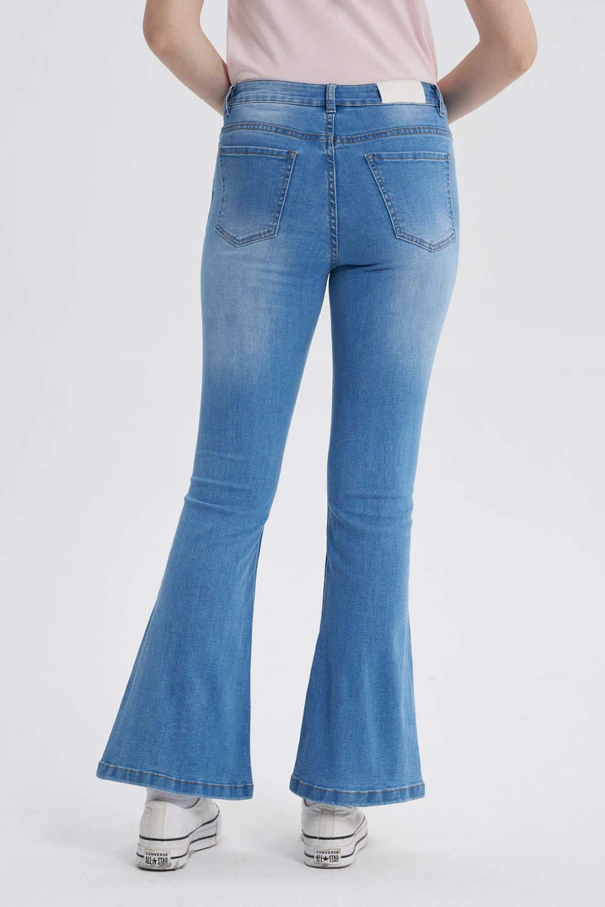 Jeans flare de mujer azul claro con diseño acampanado y cierre frontal visible