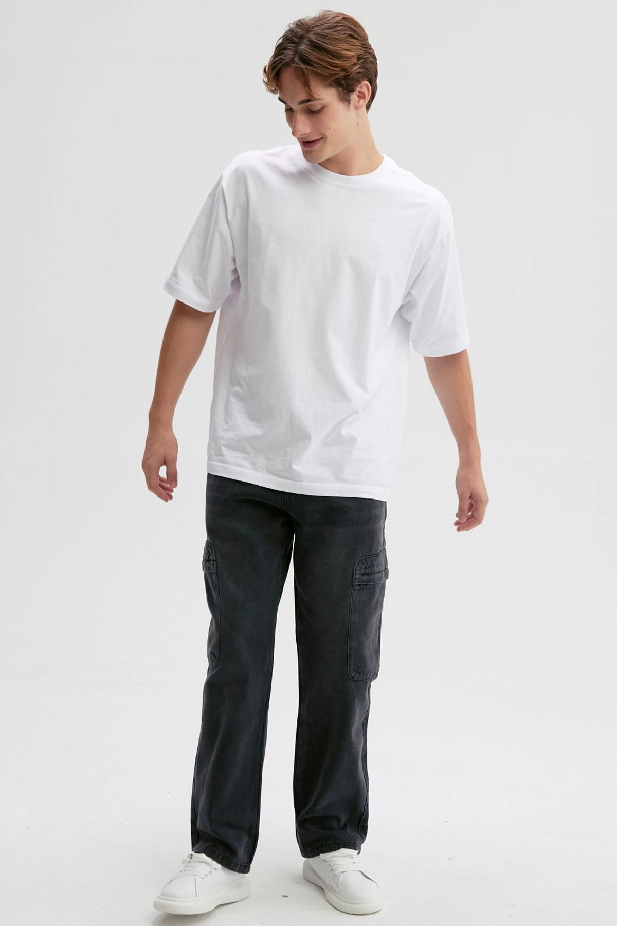 Jeans negros de hombre estilo baggy cargo con bolsillos laterales visibles