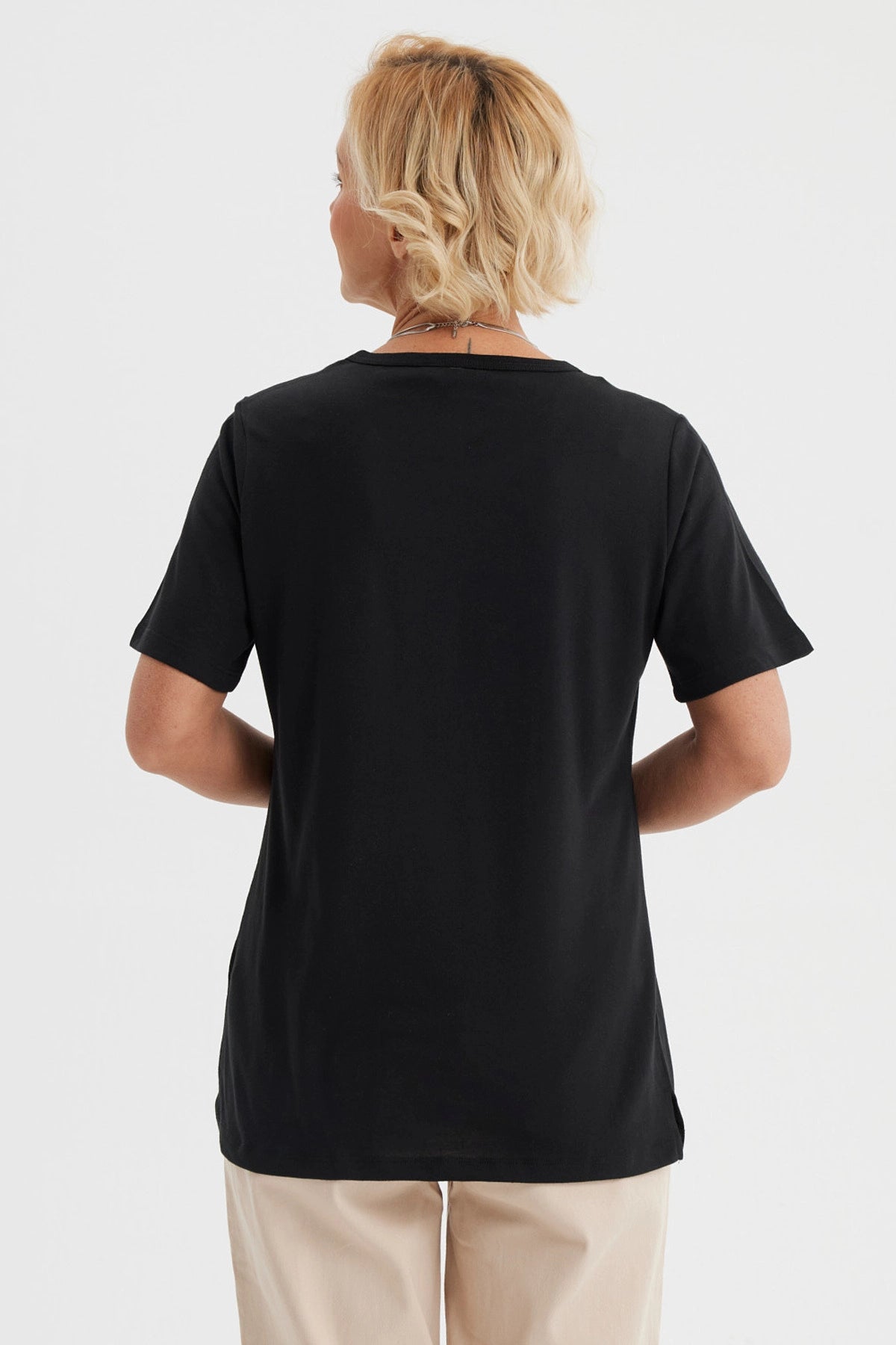 Polera negra mujer con estampado frontal de flor y texto The journey is pleasant en letras doradas