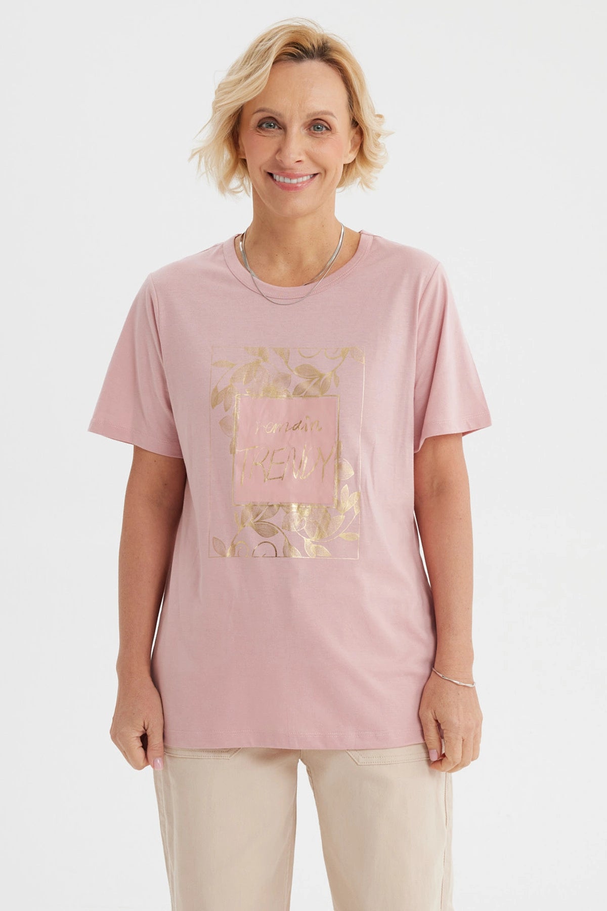 Polera mujer palo rosa con estampa frontal de hojas doradas y texto Remember Trendy en el centro estilo casual