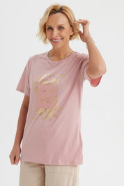 Polera mujer palo rosa con estampa frontal de hojas doradas y texto Remember Trendy en el centro estilo casual