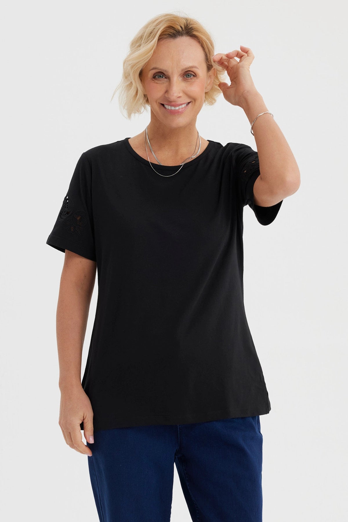 Polera negra para mujer con detalles calados en las mangas de estilo casual y sin estampa visible