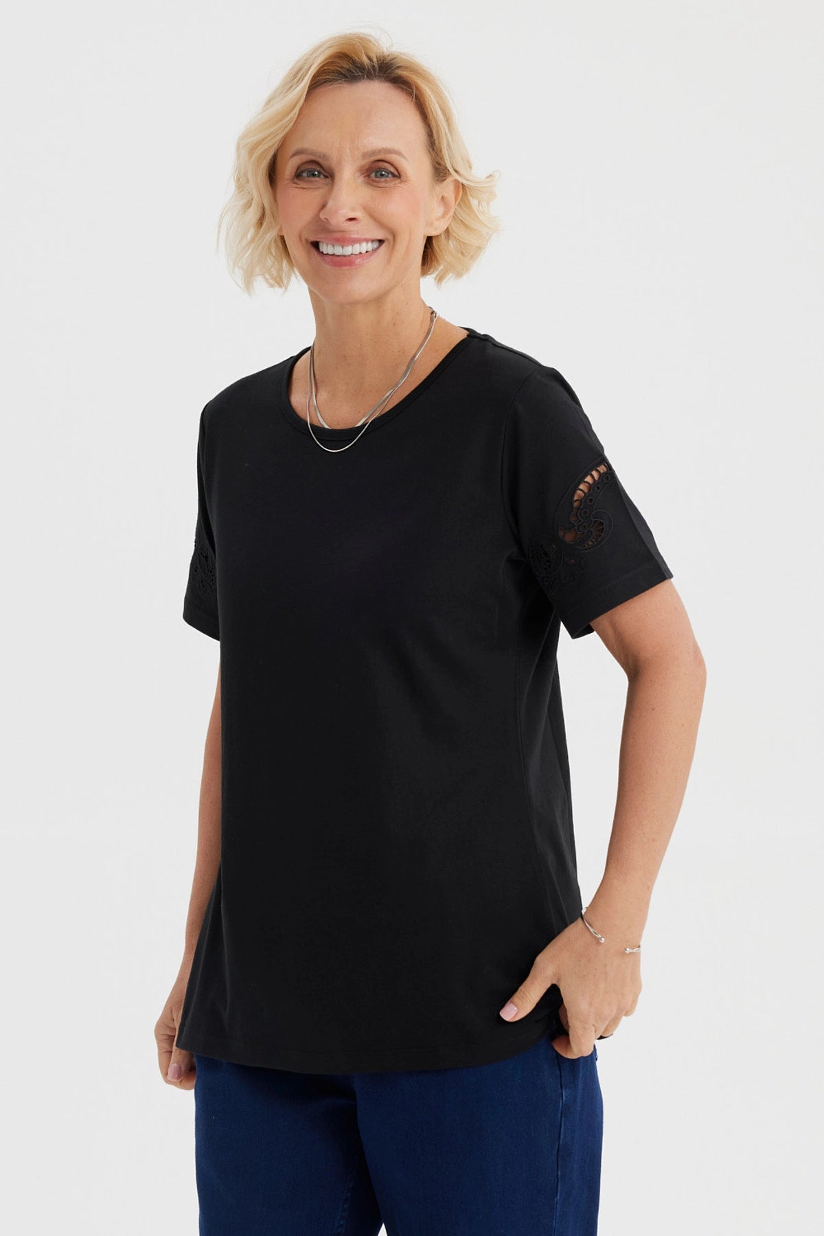 Polera negra para mujer con detalles calados en las mangas de estilo casual y sin estampa visible