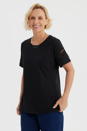 Polera negra para mujer con detalles calados en las mangas de estilo casual y sin estampa visible