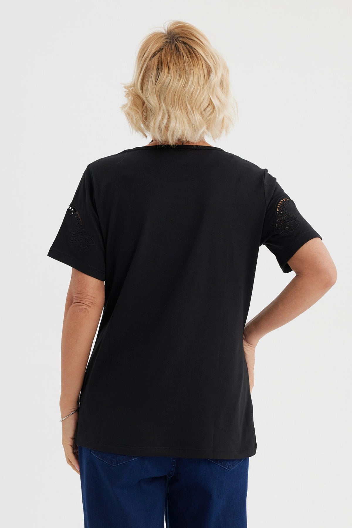 Polera negra para mujer con detalles calados en las mangas de estilo casual y sin estampa visible