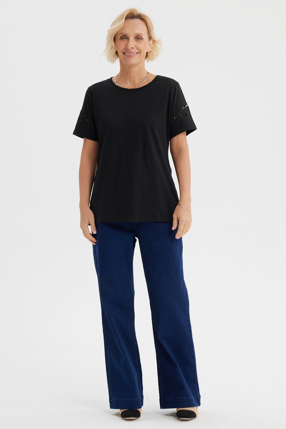 Polera negra para mujer con detalles calados en las mangas de estilo casual y sin estampa visible