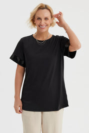 Polera negra de mujer con aplicación de encaje en las mangas lisa y de corte recto