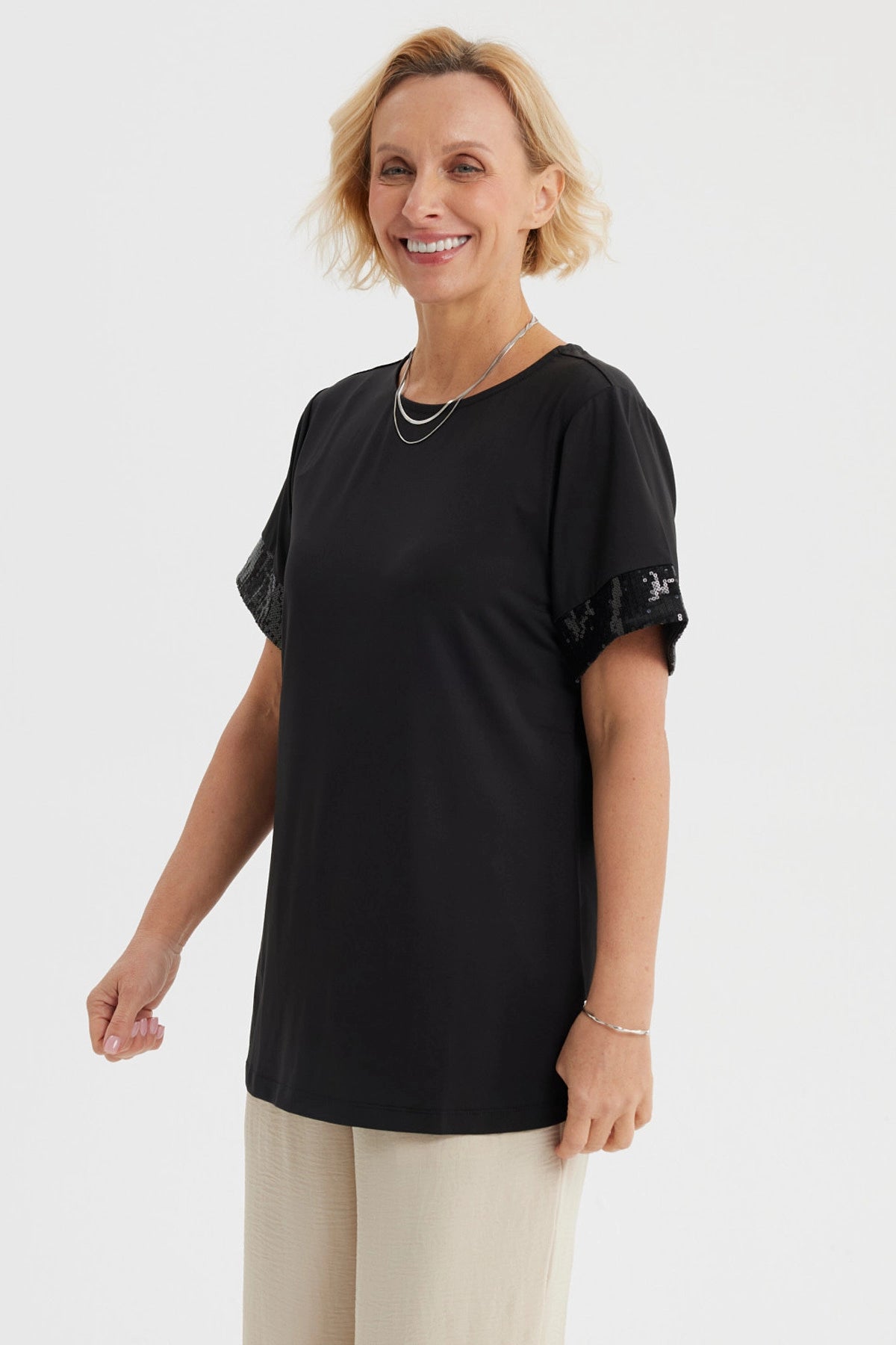 Polera negra de mujer con aplicación de encaje en las mangas lisa y de corte recto