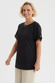 Polera negra de mujer con aplicación de encaje en las mangas lisa y de corte recto