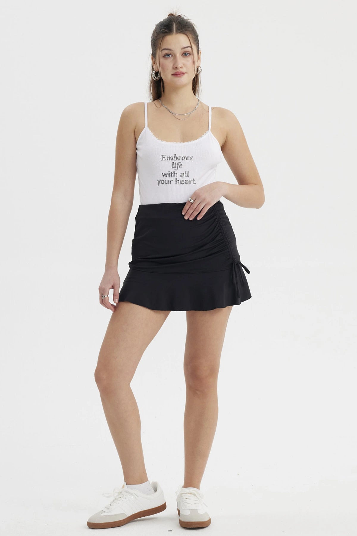 Falda corta negra ajustable en el costado con fruncido y lazo sin estampa lisa perfecta para un look casual y versátil