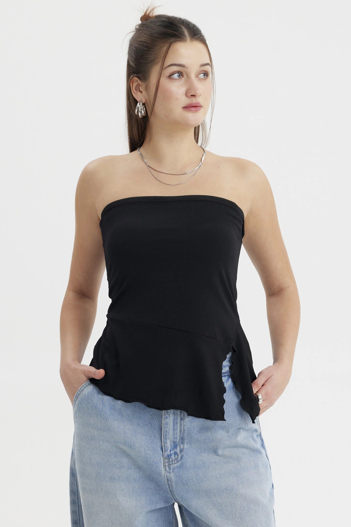 Polera strapless negra con abertura lateral detalle ondulado estilo minimalista sin estampas