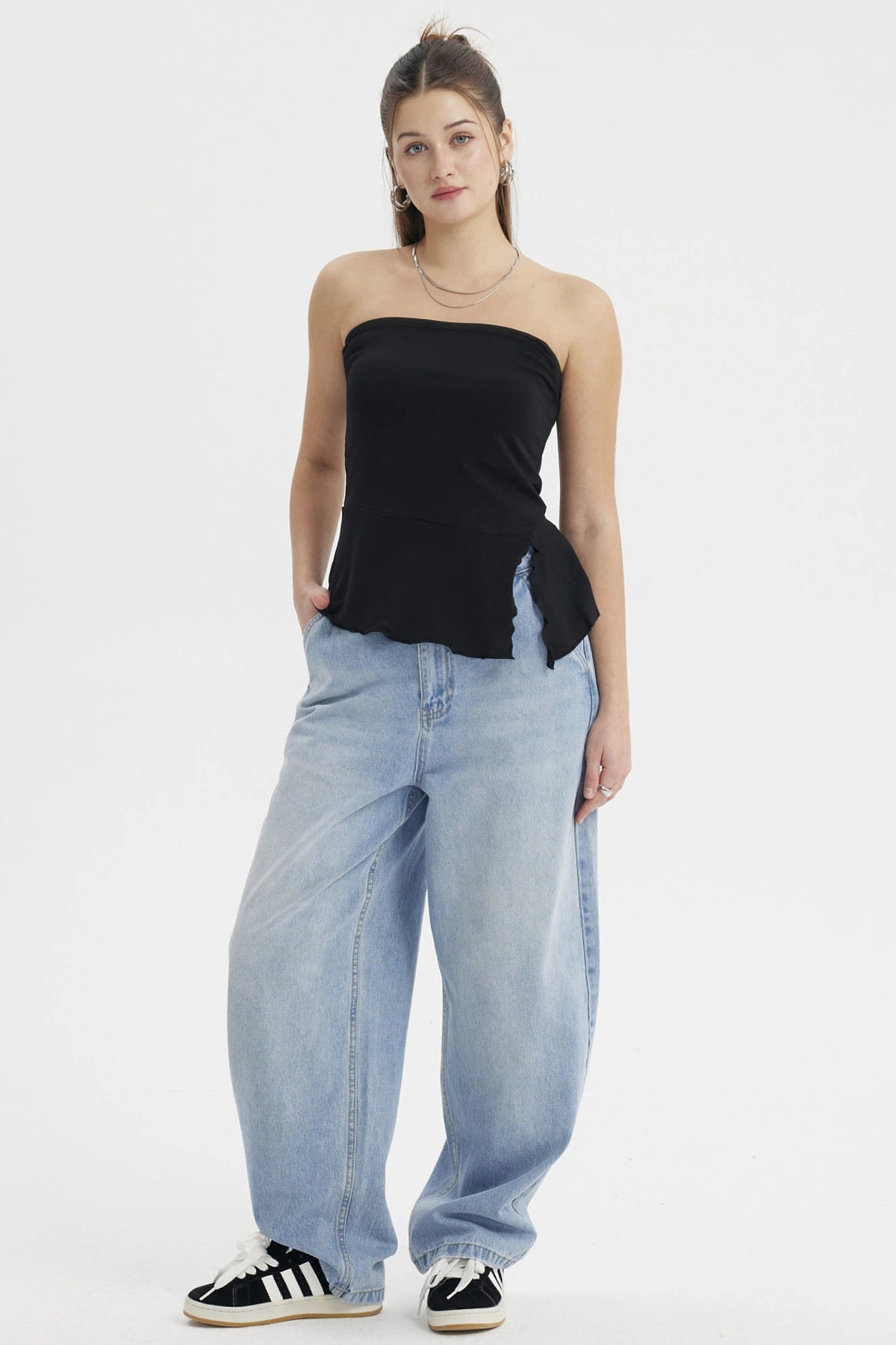 Polera strapless negra con abertura lateral detalle ondulado estilo minimalista sin estampas