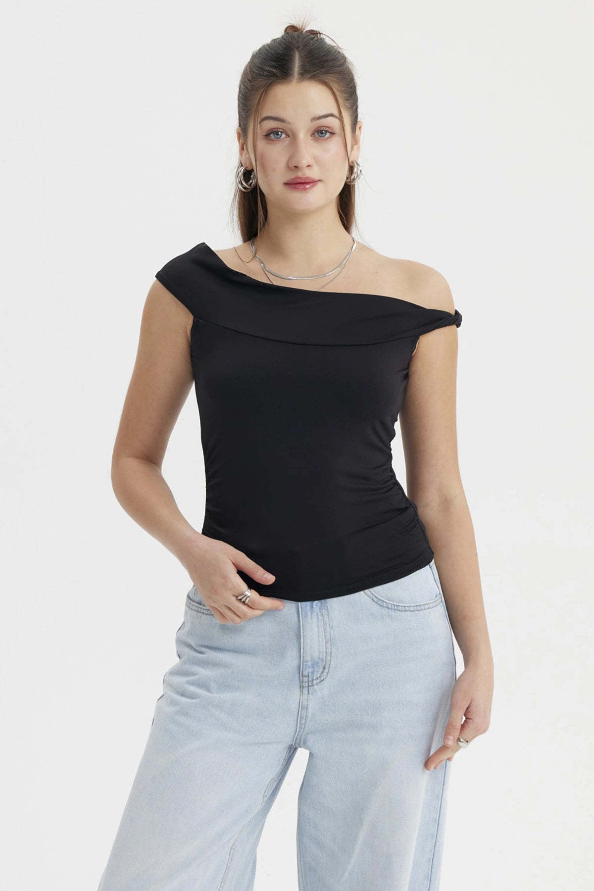 Polera negra de mujer estilo Bardot con aplicación de nudo sin estampado diseño elegante y hombro descubierto