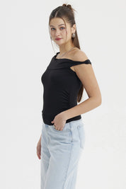 Polera negra de mujer estilo Bardot con aplicación de nudo sin estampado diseño elegante y hombro descubierto