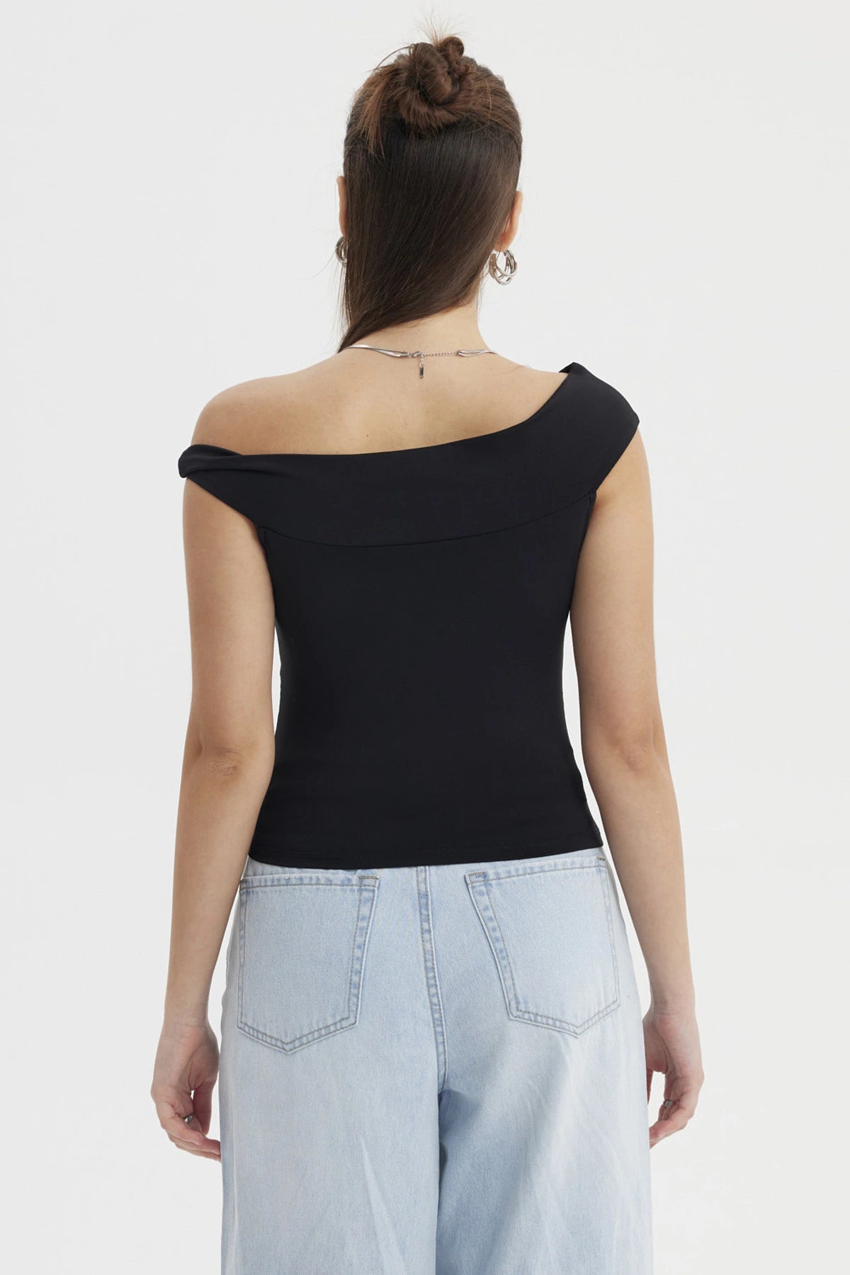 Polera negra de mujer estilo Bardot con aplicación de nudo sin estampado diseño elegante y hombro descubierto