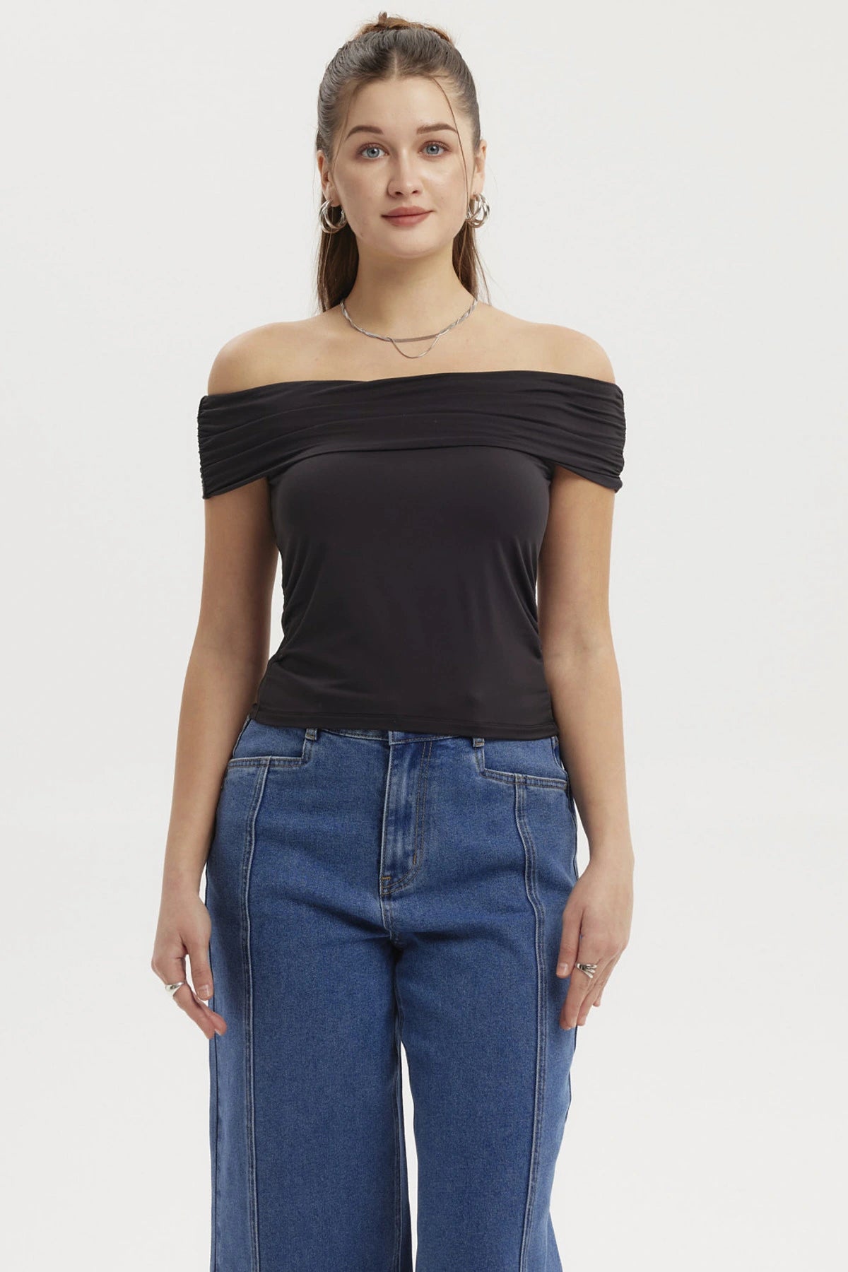 Polera negra de mujer estilo Bardot con basta redondeada y diseño liso sin estampa