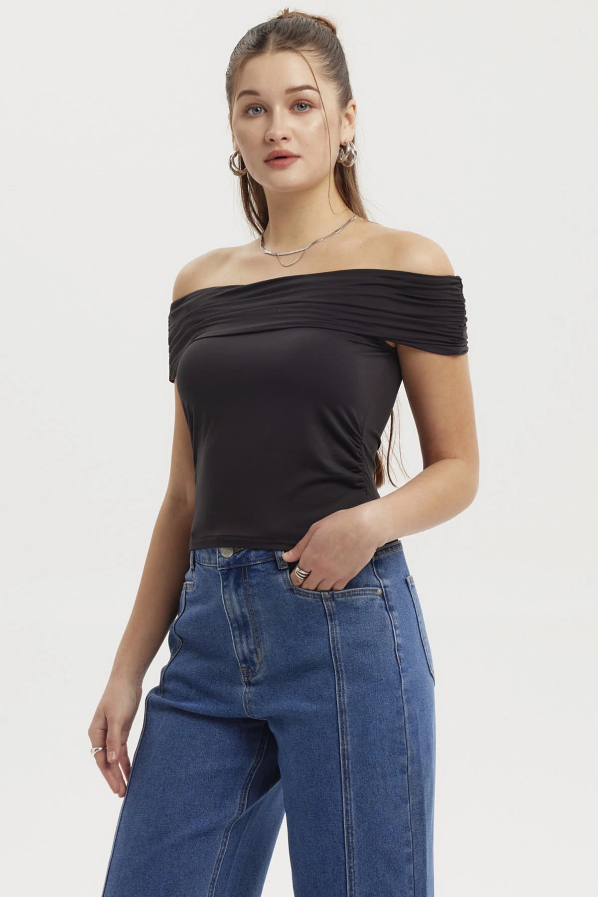 Polera negra de mujer estilo Bardot con basta redondeada y diseño liso sin estampa