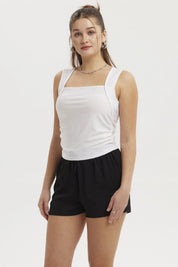Polera blanca de mujer con escote cuadrado y detalle recogido en el centro lisa y sin estampado